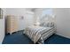 Comfortable bedroom featuring striped bedding, white furnishings, and plush blue carpeting at 1130 Hominy Hill Dr, Trinity, FL 34655