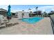 Community pool featuring a bath house, lounge chairs, tables, and sun umbrellas on a beautiful day at 1130 Hominy Hill Dr, Trinity, FL 34655