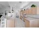 Bright kitchen featuring tile flooring, light wood cabinets, and a view into the dining area at 1130 Hominy Hill Dr, Trinity, FL 34655