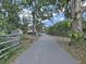 Long driveway leads to a secluded home, surrounded by mature trees and lush landscaping at 11337 Knights Griffin Rd, Thonotosassa, FL 33592