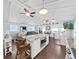 Bright living room featuring high ceilings, ceiling fans, modern lighting, and an eat-in kitchen island at 11337 Knights Griffin Rd, Thonotosassa, FL 33592