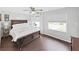 Bright bedroom with wood floors, ceiling fan, and windows looking out to greenery at 11337 Knights Griffin Rd, Thonotosassa, FL 33592