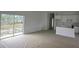 Spacious living room with sliding glass doors, connected to a kitchen with white cabinets and a breakfast bar at 11369 Gulfstream Blvd, Port Charlotte, FL 33981