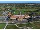 Aerial view showcasing the clubhouse, golf course, and parking area at 12 Country Club Ln, Belleair, FL 33756