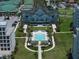 Stunning aerial view of a large building with a pool, palm trees, and manicured green spaces at 12 Country Club Ln, Belleair, FL 33756
