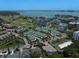 Scenic aerial view of a townhouse community near a golf course, with a waterfront and city skyline backdrop at 12 Country Club Ln, Belleair, FL 33756