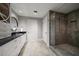 This bathroom features double sinks, black countertops, and a glass shower enclosure at 12 Country Club Ln, Belleair, FL 33756