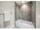 Bathroom with a tub and a modern gray tile surround, along with a glass shower door at 12 Country Club Ln, Belleair, FL 33756
