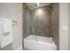 Bathroom featuring a bathtub with a glass shower door and elegant tile work at 12 Country Club Ln, Belleair, FL 33756