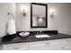 Bathroom with a granite countertop vanity, stylish mirror, and modern sconces at 12 Country Club Ln, Belleair, FL 33756