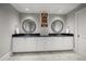 This bathroom features double sinks, black countertops, and twin round mirrors at 12 Country Club Ln, Belleair, FL 33756