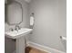 Powder room featuring a pedestal sink, hardwood floors, and modern fixtures at 12 Country Club Ln, Belleair, FL 33756