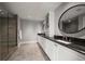 Bathroom features a spacious walk-in shower, double sink vanity with granite countertop and round mirrors at 12 Country Club Ln, Belleair, FL 33756