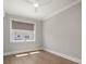Bedroom with hardwood floors, a ceiling fan, and a large window with privacy shades at 12 Country Club Ln, Belleair, FL 33756
