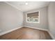 Bedroom with light neutral paint, hardwood floors, and a large window at 12 Country Club Ln, Belleair, FL 33756