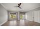 Light bedroom boasts hardwood floors, neutral walls, ceiling fan and view of the yard at 12 Country Club Ln, Belleair, FL 33756