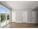 Bedroom with hardwood floors and sliding glass doors to balcony at 12 Country Club Ln, Belleair, FL 33756