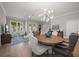 Elegant dining room with hardwood floors and a modern chandelier and living room view at 12 Country Club Ln, Belleair, FL 33756