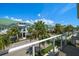 View of community with lush landscaping and green roofs seen from the balcony with a glass enclosure at 12 Country Club Ln, Belleair, FL 33756