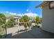View of community with lush landscaping and green roofs seen from the balcony with a glass enclosure at 12 Country Club Ln, Belleair, FL 33756