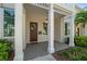 Charming front porch with wood door, stylish lighting, and manicured landscaping at 12 Country Club Ln, Belleair, FL 33756