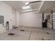 An open garage with a concrete floor featuring garage door mechanism and electrical charging outlets at 12 Country Club Ln, Belleair, FL 33756