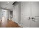 Hallway with hardwood floors and white doors, leading to balcony at 12 Country Club Ln, Belleair, FL 33756