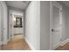 Hallway featuring a bathroom with modern fixtures and a cabinet, with wooden floors and white trim at 12 Country Club Ln, Belleair, FL 33756