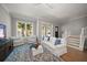 Bright living room featuring hardwood floors, a large rug, and white furniture at 12 Country Club Ln, Belleair, FL 33756