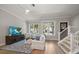 Sunlit living room showcases wood floors, white furniture, and modern entertainment setup at 12 Country Club Ln, Belleair, FL 33756