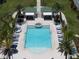 Aerial view of pool area with lounge chairs, palm trees, and a hot tub at 12 Country Club Ln, Belleair, FL 33756
