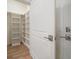 Walk-in closet with custom shelving and hardwood flooring at 12 Country Club Ln, Belleair, FL 33756