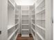 Spacious walk-in closet with custom shelving and hardwood floors at 12 Country Club Ln, Belleair, FL 33756