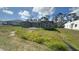 New construction home with a gray exterior and large windows surrounded by a grassy yard at 12047 Henley Ave, Port Charlotte, FL 33981