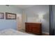 Cozy bedroom features a wooden dresser with artwork, lamp, and stylish accents at 12808 Killarney Ct, Odessa, FL 33556