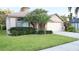 Inviting single-story home showcasing a manicured lawn, mature palm trees, and an attached two-car garage at 12808 Killarney Ct, Odessa, FL 33556