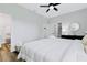 Spacious bedroom boasting a ceiling fan, bedside tables, wood laminate flooring, and access to a bathroom at 13266 Drysdale Ave, Port Charlotte, FL 33981