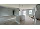 An open-concept living space is in progress with gray walls, modern lighting, and a base for a kitchen island at 13266 Drysdale Ave, Port Charlotte, FL 33981