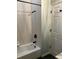 Bright bathroom featuring a white tub with black fixtures and tiled walls at 14510 Mj Rd, Myakka City, FL 34251
