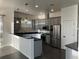 Modern kitchen with grey cabinets, stainless steel appliances, and black countertops at 14510 Mj Rd, Myakka City, FL 34251