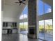 Bright living room with a stone fireplace, tall windows, and built in wet bar at 14510 Mj Rd, Myakka City, FL 34251