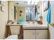 Well-lit half bath with vanity, sink, and toilet, decorated with blue accents and wall art at 15202 Heathridge Dr, Tampa, FL 33625