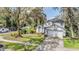 Beautifully landscaped front yard with mature trees shading a two-story house and driveway at 15202 Heathridge Dr, Tampa, FL 33625