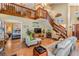 Open-concept living room with a staircase, wood floors, and large windows for ample natural light at 15202 Heathridge Dr, Tampa, FL 33625