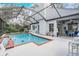 Screened-in pool area with an inviting pool and an adjacent covered patio with seating at 15202 Heathridge Dr, Tampa, FL 33625