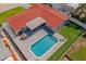 Aerial view of a home featuring an in-ground pool, screened-in porch, and a patio dining area at 1546 69Th S Pl, St Petersburg, FL 33705