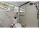 Bright bathroom featuring white tiles, a glass shower, and a window at 1546 69Th S Pl, St Petersburg, FL 33705