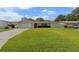 Charming single-story home featuring a well-manicured lawn, a red front door, and a gray driveway at 1546 69Th S Pl, St Petersburg, FL 33705