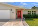 Close-up of home's entrance and front porch featuring tile, stone landscaping, and a red front door at 1546 69Th S Pl, St Petersburg, FL 33705