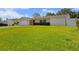 Charming single-story home featuring a lush green lawn and bright red front door at 1546 69Th S Pl, St Petersburg, FL 33705